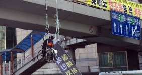 육교에 매달린 장애인