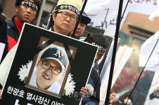 한광호 영정 든 김성민 지회장[포토]