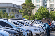 전주시 장동 중고차 매매 단지에서 중고차를 꼼꼼히 살펴보는 소비자