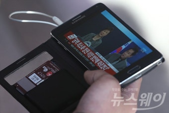 [포토]‘DMB로 박근혜 대통령 대국민담화 지켜보는 시민’
