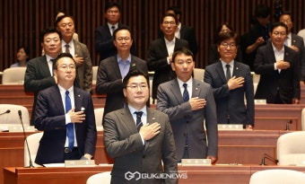 국기에 경례하는 박찬대 당대표 직무대행 겸 원내대표와 의원들
