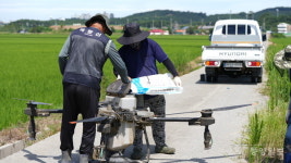 드론을 이용해 비료주는 농업인