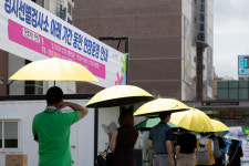 체감 온도 35도…양산 쓰고 검사 기다리는 시민들