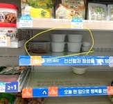비어 있는 진열대 냉장칸에 개인 음식 보관하는 어느 GS25 편의점 알바생