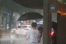버스정류장에서도 우산을 써야[포토]