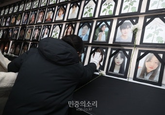 이태원 참사 희생자 영정 사진을 어루만지는 유가족