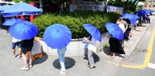 선별진료소, 불볕 더위 피하려 우산든 시민들