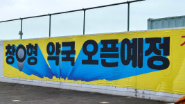 수원 택지지구에 등장한 창O형 약국 현수막, 복잡한 지역 민심