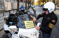 수험생 탑승 안내문 부착하는 오토바이 봉사대원 [포토]