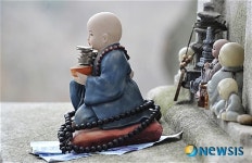 동전을 한아름 않은 동자승