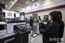 (주)알파어셈블리솔루션코리아 | 티셔츠 프린팅 솔루션 살펴보는 참관객들