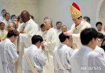 안수받는 사제 수품 후보자들