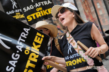 구호 외치는 미 파업 작가와 배우들