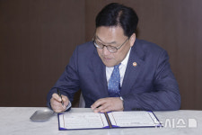 서명하는 김병환 금융위원장