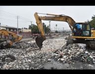 A backhoe loader removes garbage to clean the canal of Portail Leogane in the Haitian capital of Port-au-Prince, on October 3... 