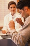 Man looking at glasses in optical shop 이미지 (E003177) - 게티이미지뱅크 Man looking at glasses in optical shop