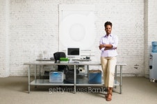 Businesswoman standing with arms folded leaning against a desk 이미지 (bldcb0406fdn_0003) - 게티이미지뱅크 Businesswoman... 