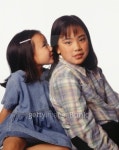 Young girl (6-7) whispering to sister (8-9), posing in studio, portrait 이미지 (200269802-001) - 게티이미지뱅크 Young girl... 
