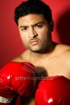 Young male boxer wearing boxing gloves looking at camera... 게티이미지뱅크 Young male boxer wearing boxing gloves looking at camera