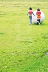 Girls pushing a large white ball through a field 이미지 (100611244) - 게티이미지뱅크 Girls pushing a large white ball through... 