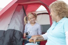 Grandmother and grand-daughter sit at entrance to tent 이미지 (98360857) - 게티이미지뱅크 Grandmother and grand-daughter sit... 