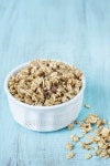 Almond Breakfast Cereal Granola In White Bowl On Blue Background... Almond Breakfast Cereal Granola In White Bowl On Blue Background