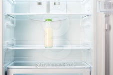 Glass bottle of yoghurt on shelf of open empty refrigerator... Glass bottle of yoghurt on shelf of open empty refrigerator