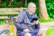 Man with tablet PC near bicycle in the park 이미지 (482625866) - 게티이미지뱅크 Man with tablet PC near bicycle in the park