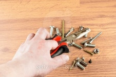 Pliers in hand on a background of various bolts 이미지 (479207956) - 게티이미지뱅크 Pliers in hand on a background of various... 