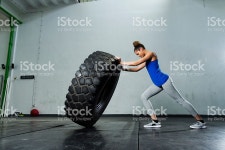 Young Girl Flipping Tire At The Gym stock photo 521613968 | iStock Side view of young woman picking up tractor tire in the gym