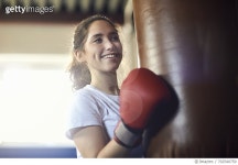 702540759 | 게티이미지코리아 | Young female boxer punching punch bag in gym Royalty-Free 이미지