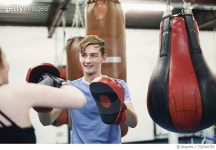 702540765 | 게티이미지코리아 | Female boxer training, punching teammates punch mitt Royalty-Free 이미지