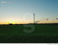 702688485 | 게티이미지코리아 | Wind Turbines On Grassy Field At Sunset Royalty-Free 이미지