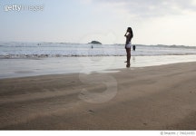 709224353 | 게티이미지코리아 | Side View Of Woman Standing At Beach Against Sky Royalty-Free 이미지