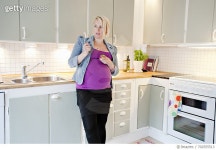 702555513 | 게티이미지코리아 | Pregnant woman eating snack in kitchen Royalty-Free 이미지
