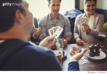 702546165 | 게티이미지코리아 | Friends playing poker and drinking beer and wine at table in bar Royalty-Free 이미지
