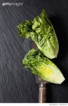 709127477 | 게티이미지코리아 | Whole and sliced romaine lettuce and an old knife on slate Royalty-Free 이미지