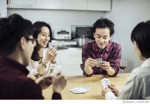 667661408 | 게티이미지코리아 | Group of friends enjoying card game at home. Royalty-Free 이미지