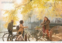 713774451 | 게티이미지코리아 | Friends with bicycles along sunny autumn canal in Amsterdam Royalty-Free 이미지
