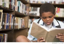 675773980 | 게티이미지코리아 | African descent boy in school library reading book. Royalty-Free 이미지