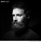 722308477 | 게티이미지코리아 | Close-Up Portrait Of Serious Young Man Against Black Background Royalty-Free 이미지