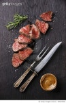 696670560 | 게티이미지코리아 | Sliced medium rare Roast beef with table knife and fork for meat on dark background Royalty-Free... 