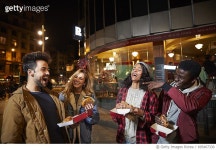 695407330 | 게티이미지코리아 | Happy friends enjoying burgers in city at night Royalty-Free 이미지