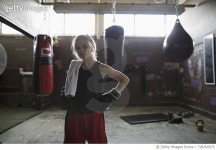 728760975 | 게티이미지코리아 | Portrait tough girl boxer wearing boxing gloves near punching bags in gym Royalty-Free 이미지