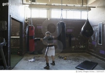 728761875 | 게티이미지코리아 | Serious, strong female boxer boxing at punching bag in gritty gym Royalty-Free 이미지