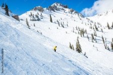 Skier descending snowy slope by mountain Stock Photo | Adobe Stock Skier descending snowy slope by mountain  Stock Photo