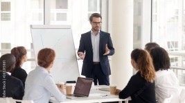 Male business coach speaker in suit give flipchart presentation Stock Photo | Adobe Stock Male business coach speaker in suit... 