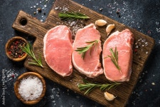 Pork meat. Fresh pork steaks on cutting board with ingredients for cooking. Top view at black stone table. Stock Photo | Adobe... 