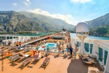 Tourists on a large cruise ship on Boka Bay near Perast heading towards the Kotor Montenegro cruise port on the Adriatic Sea.... 