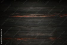 Interior of modern bedroom with black and orange walls, concrete floor, comfortable king size bed with two bedside tables and... 